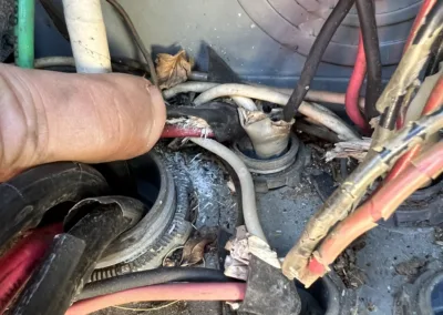 A hand is holding a wire in a refrigerator.