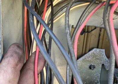 A person holding a wire in a box of wires.