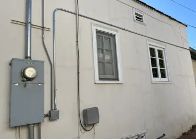 A white house with a light on the side of it.