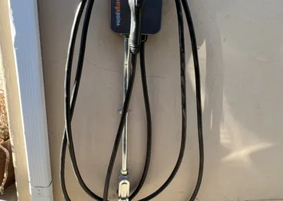 An electric car charging station on the side of a house.