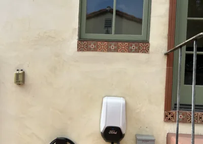 An electric car charging station on the side of a house.