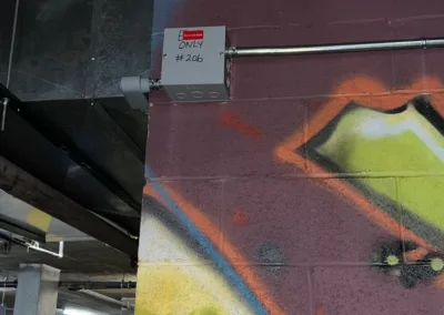 A graffiti covered wall in a parking garage.