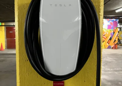 A tesla charging station in a parking garage.