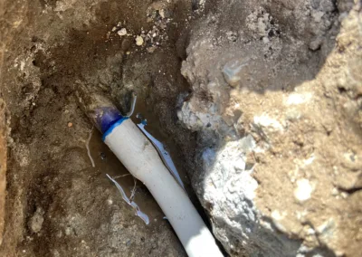 A water hose in a hole in the ground.