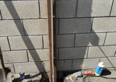 A pipe is being installed next to a wall.