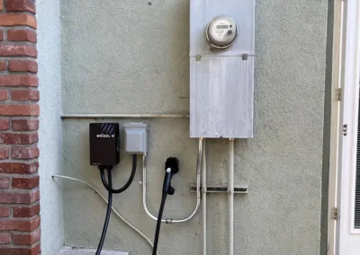 An electric car charging station on the side of a house.